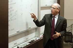 Saul Levmore points at a whiteboard.