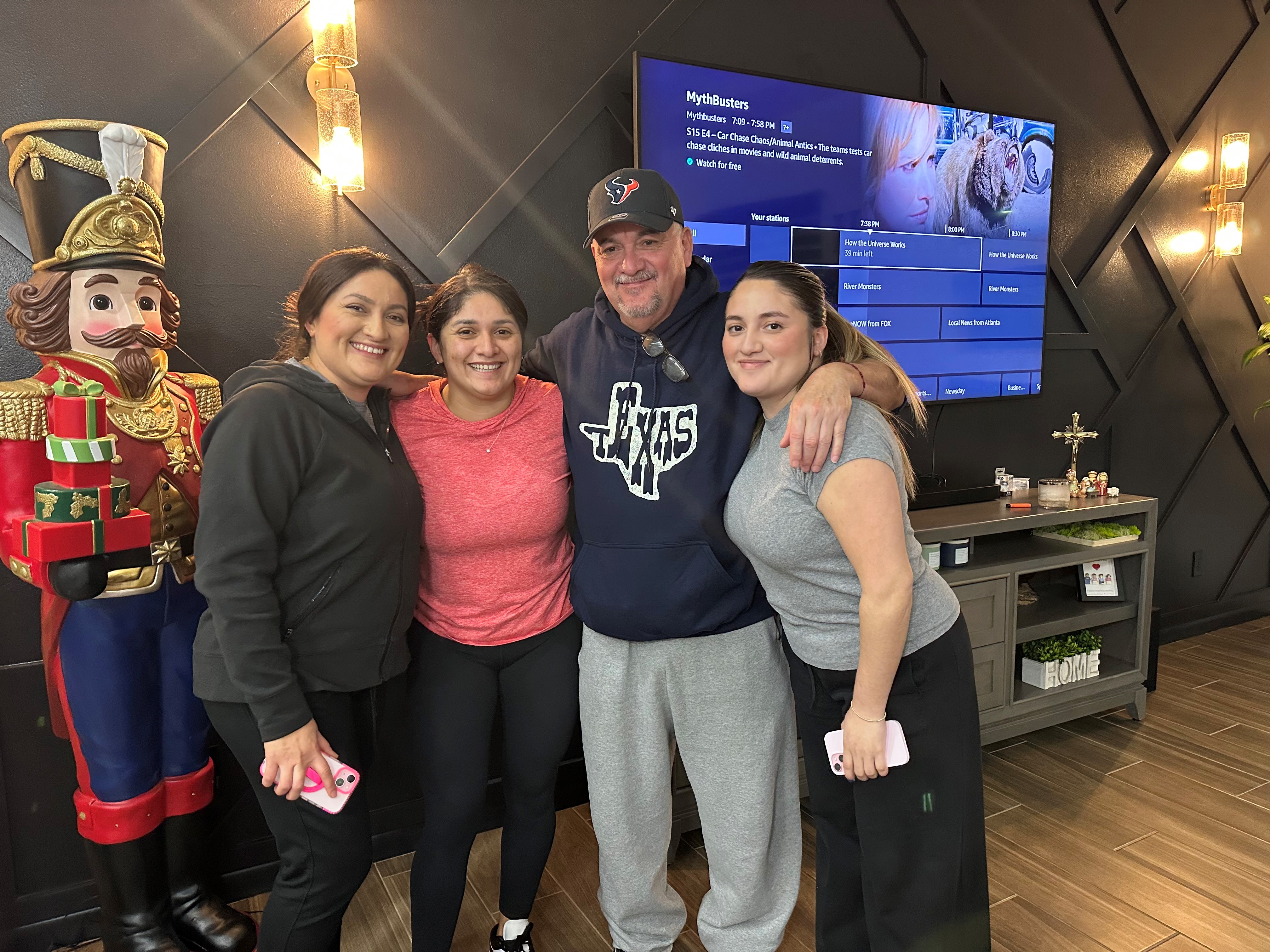 Jasper Vargas stands side by side happily with his three adult daughters.