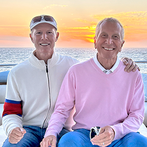 Marc and Barry now on a boat with the sunset behind them.