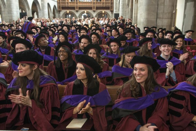 Graduates of the Law School applaud in their hoods after the ceremony.