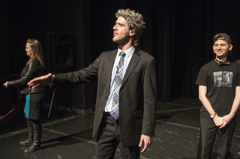 A student playing Professor Geoffrey R. Stone conducts a microphone check—in character.