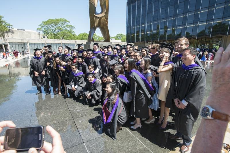 LLM graduates took photos in the Law School's fountain after the ceremony.