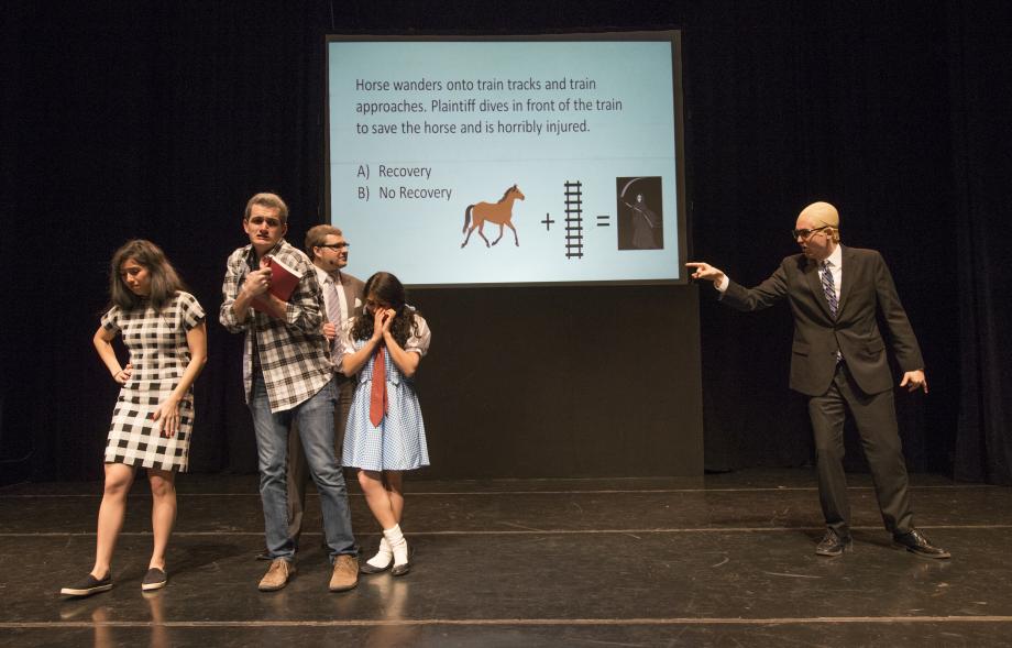 David Smith, '20, as Professor Saul Levmore, asks Dorothy and others a hypothetical before they enter the Emerald Lounge.