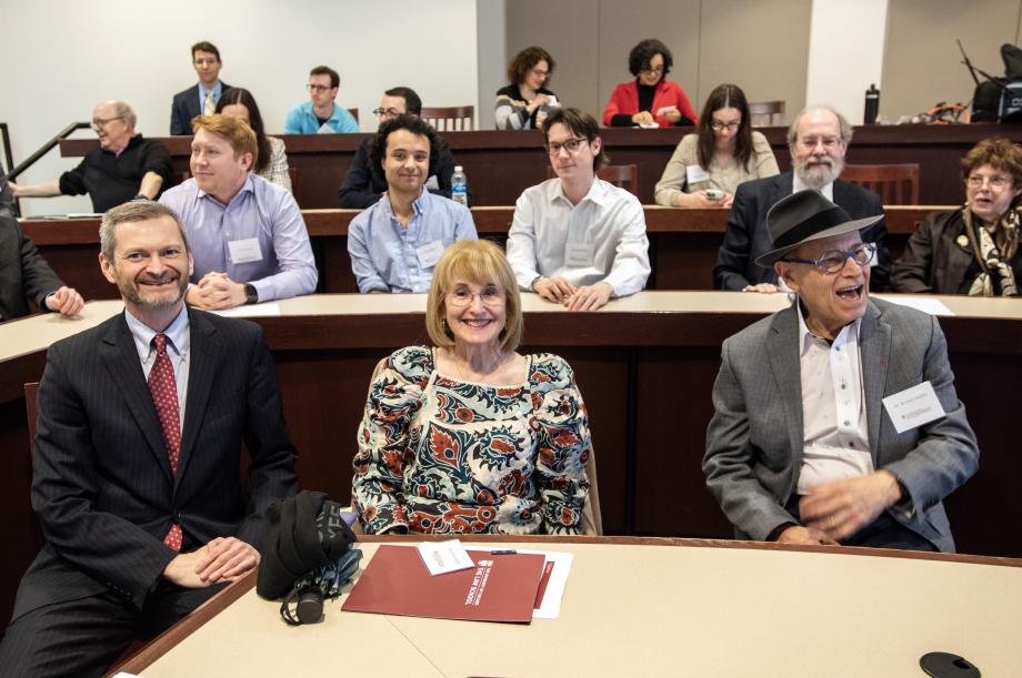 People sitting in a classroom smiling and socializing.