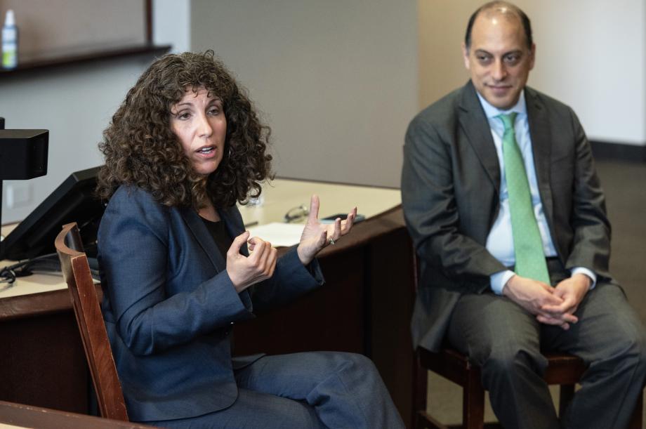 A woman and a man sitting next to each other on two separate chairs.