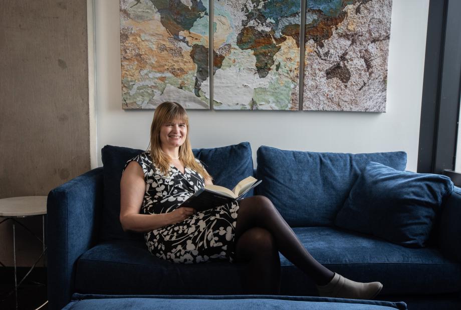 A woman sitting on a couch with a book on her lap