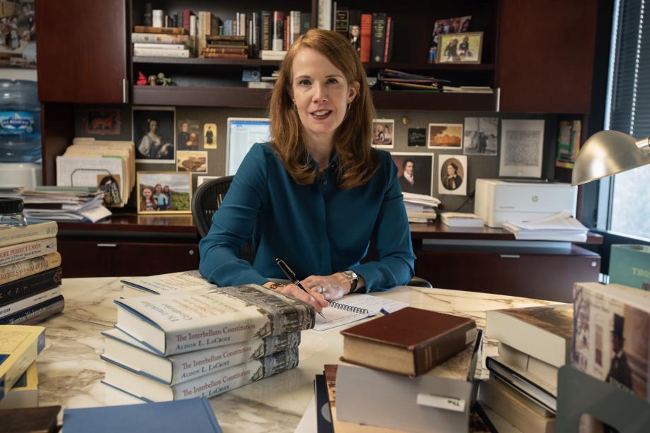 Alison LaCroix sits at her desk with a stack of The Interbellum Constitution