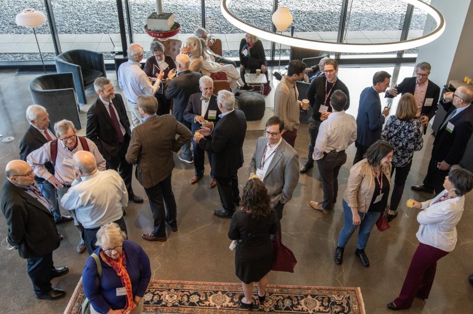 A high-angled view of people standing an socializing in a big room.