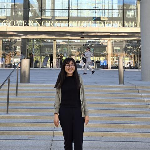 Sabrina Huang stands outside a glass and steel building.