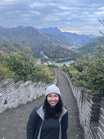 Isabel Ayala poses for the camera in front of a mountainous landscape.