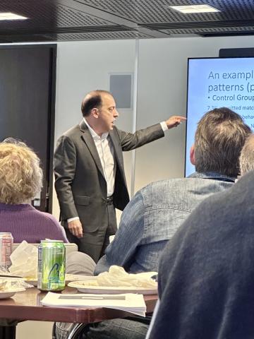 Lior Strahilevitz standing and pointing at his PowerPoint presentation 