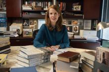 Alison LaCroix sits at her desk with a stack of The Interbellum Constitution