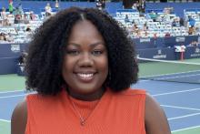 Chauntell Bobo wears a red blouse on a tennis court.